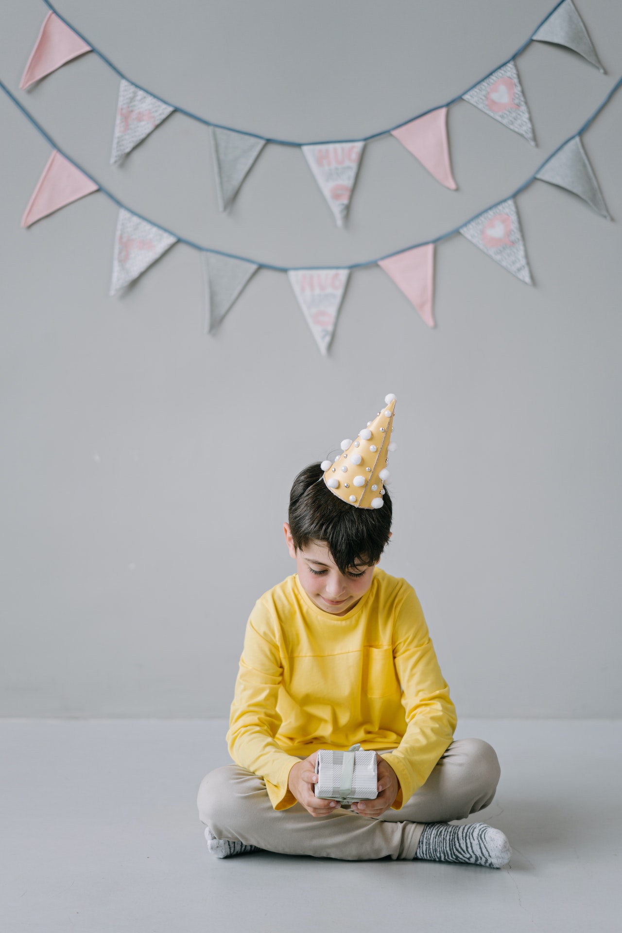 chłopiec w żółtej bluzie i czapeczce urodzinowej